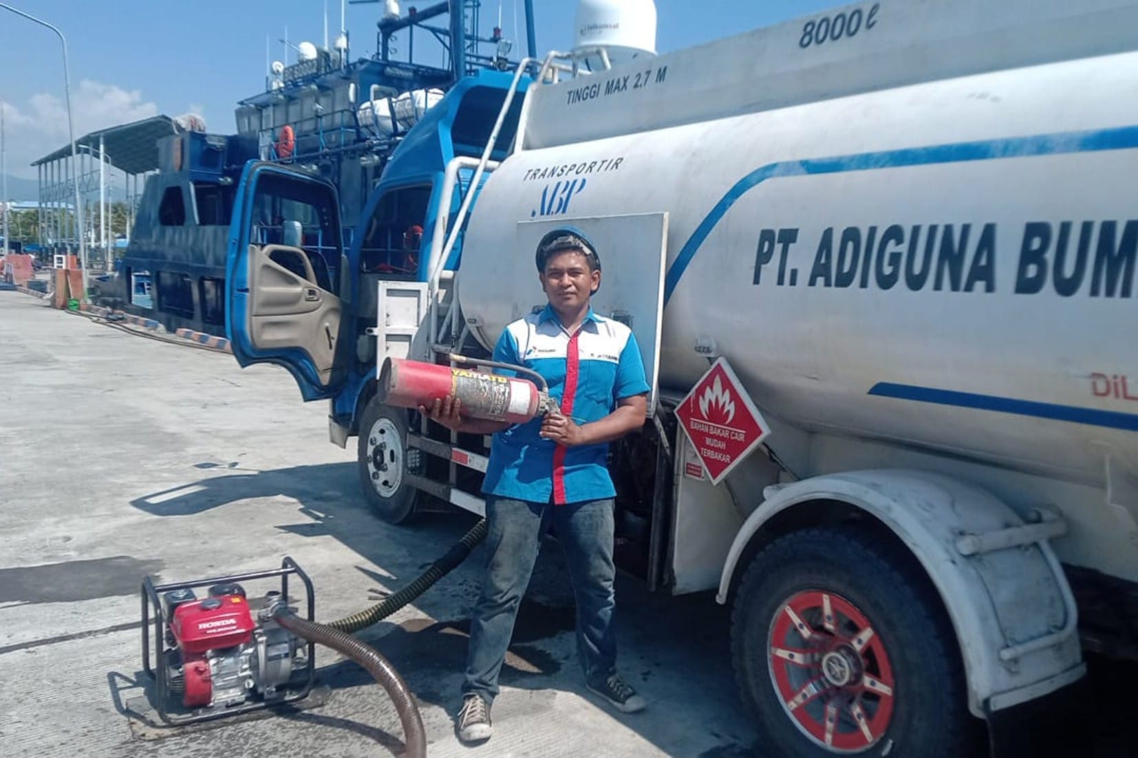 Personel memeriksa peralatan mobil tangki Adiguna dalam dokumentasi layanan transportasi